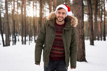 attractive bearded man standing outdoors in winter season forest.