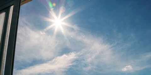 bright rays of sun shines through glass window frame in hot summer day
