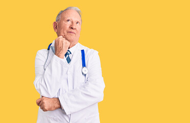 Senior handsome grey-haired man wearing doctor coat and stethoscope with hand on chin thinking about question, pensive expression. smiling and thoughtful face. doubt concept.