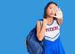 © Krakenimages.com - Young beautiful chinese girl wearing cheerleader uniform holding student backpack with open hand doing stop sign with serious and confident expression, defense gesture