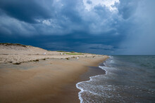 Dark Storm Clouds Incoming Above Sandy Beach Shoreline.