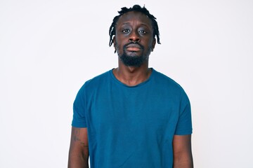 Young african american man with braids wearing casual clothes relaxed with serious expression on face. simple and natural looking at the camera.