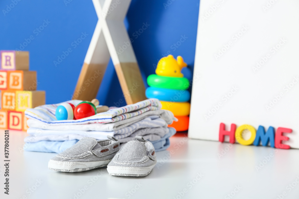 Children's toys with clothes on table in room