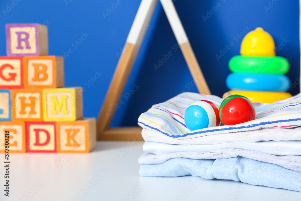 Children's toys with clothes on table in room