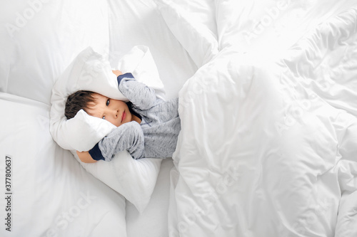 Fotografía Little boy suffering from sleep disorder in bedroom