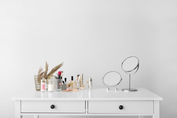 Set of decorative cosmetics and mirrors on dressing table