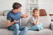 © Pixel-Shot - Father trying to make peace with son after quarrel at home