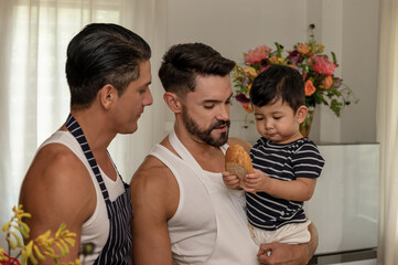 Young married LGBT couples celebrate a romantic moment together with adopted child to become parents