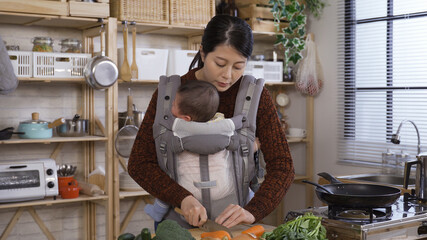 charming asian japanese female parent cutting carrots and calming with verbal soothing her cute baby girl in morning kitchen.