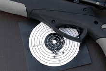 air gun, paper shooting target with bullet holes and airgun pellets