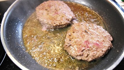 Wall Mural - Cooking juicy tasty burger meat on hot pan with spatula in the kitchen at home