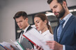 © zinkevych - Brown-haired female and two male colleagues reading papers