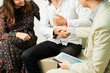 © DragonImages - Close-up of man sitting together with woman on sofa and shaking hands to businessman after financial consultation at office