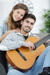 loving couple with guitar in the room at home