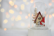 Christmas Background. Decorative Figurine Of Christmas Theme In A Glass Ball Against A Background Of Warm Bokeh. Space For Text, Side View.