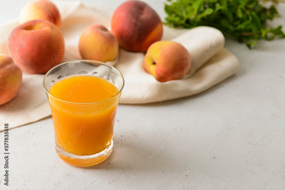 Glass of fresh peach juice on table
