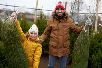 Sticker - family, winter holidays and people concept - happy father and little daughter buying christmas tree at street market