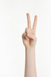 © Image Republic - woman's hand making peace sign on white background