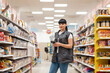 © _KUBE_ - A young Caucasian woman, an employee of a supermarket, poses in the aisle of the store, between the rows of goods. Concept of business, shopping and work