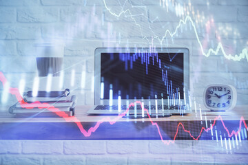 Stock market graph on background with desk and personal computer. Multi exposure. Concept of financial analysis.