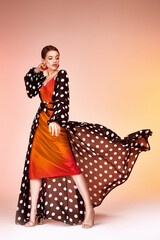 Glamour fashion woman long brunette hair natural evening makeup wear sexy silk long dress polka dot and red stylish from new catalog spring summer collection accessory jewelry earring body shape care.