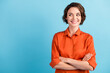 Photo of funny attractive cheerful lady bobbed hairdo arms crossed self-confident person worker good mood look side empty space sly eyes wear orange office shirt isolated blue color background