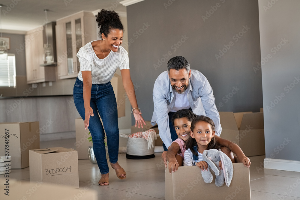 Parents playing with children while moving into new home - obrazy, fototapety, plakaty 