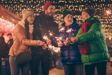 Poster - Portrait of nice attractive cheerful family having fun spending time street urban market newyear celebration burning bengal festal fire custom eve noel spirit outside outdoor