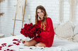 © Тарас Нагирняк - beautiful blonde woman holding bouquet of red roses and posing on the camera.