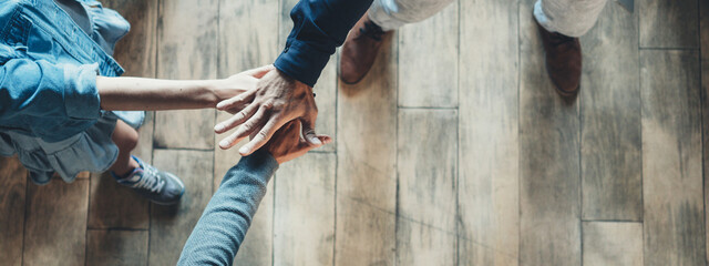 Business office concept. Three employees shaking hands together after successful meeting. Wide screen, panoramic