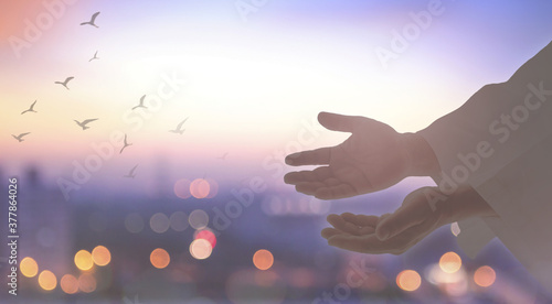 Fotomural Silhouette human open two empty hands with palms up and birds flying over blurre