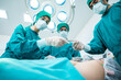 © chokniti - Surgeon Medical Team Performing Emergency Surgical Operation in Bright Modern Operating Room
