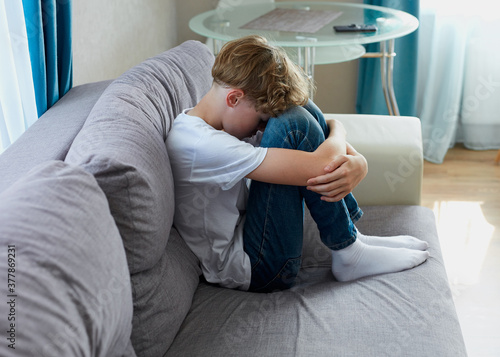 Fotomural teenage boy suffer from cyberbullying, offended boy sit alone at home