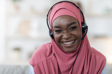 Portrait of african muslim woman in hijab and headset at home