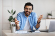 © Prostock-studio - Young indian freelancer guy sitting at desk in office, talking at camera