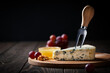 Blue cheese with fork on cut wooden board
