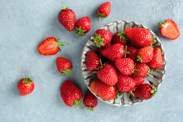 Strawberries on grey concrete background. Top view. Organic red berries