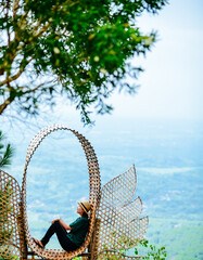 Single Asian girl having fun on mountain park at Hutan Pinus Pengger, Yogyakarta, Indonesia.