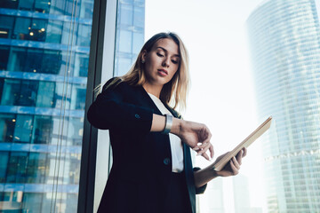 Elegant business woman in modern office looking at wrist watch