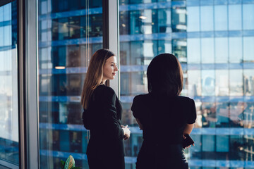 Confident female colleagues dressed in formal wear talking about business in office company, Caucasian woman employees discussing planning and ideas for briefing cooperation of corporate firms