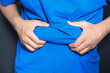 © Towfiqu Barbhuiya  - man's hand holding excessive belly fat, overweight concept