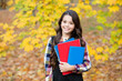 © be free - concept of knowledge day. kid in autumn park. happy kid with books in autumn leaves. small girl wear uniform. back to school. modern education. child with notebooks in fall forest