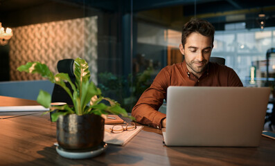 Businessman working after hours on a laptop in an office