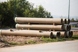 Fototapeta Łazienka - Large sewer pipes, slid along the road, ready for installation, reconstruction of roads and sewer networks