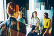 © BullRun - Group of youthful hipsters communicating during friendly meeting for brainstorming collaboration in coworking space, successful multicultural students discussing project ideas while cooperating