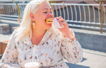 Chubby nice happy plus size woman eat burger in good mood outdoor, stop diet happy life and body positive concept