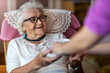 © pikselstock - Helpful home healthcare nurse gives a senior female a cup of hot tea
