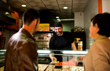 Couple buying and choosing pizza at street outdoors restaurant.