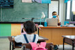 © visoot - Teacher wearing protective mask to Protect Against Covid-19 with elementary student  in classroom online after covid-19 quarantine and lockdown,New normal lifestyle during corona virus.