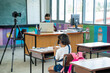 © visoot - Teacher wearing protective mask to Protect Against Covid-19 with elementary student  in classroom online after covid-19 quarantine and lockdown,New normal lifestyle during corona virus.